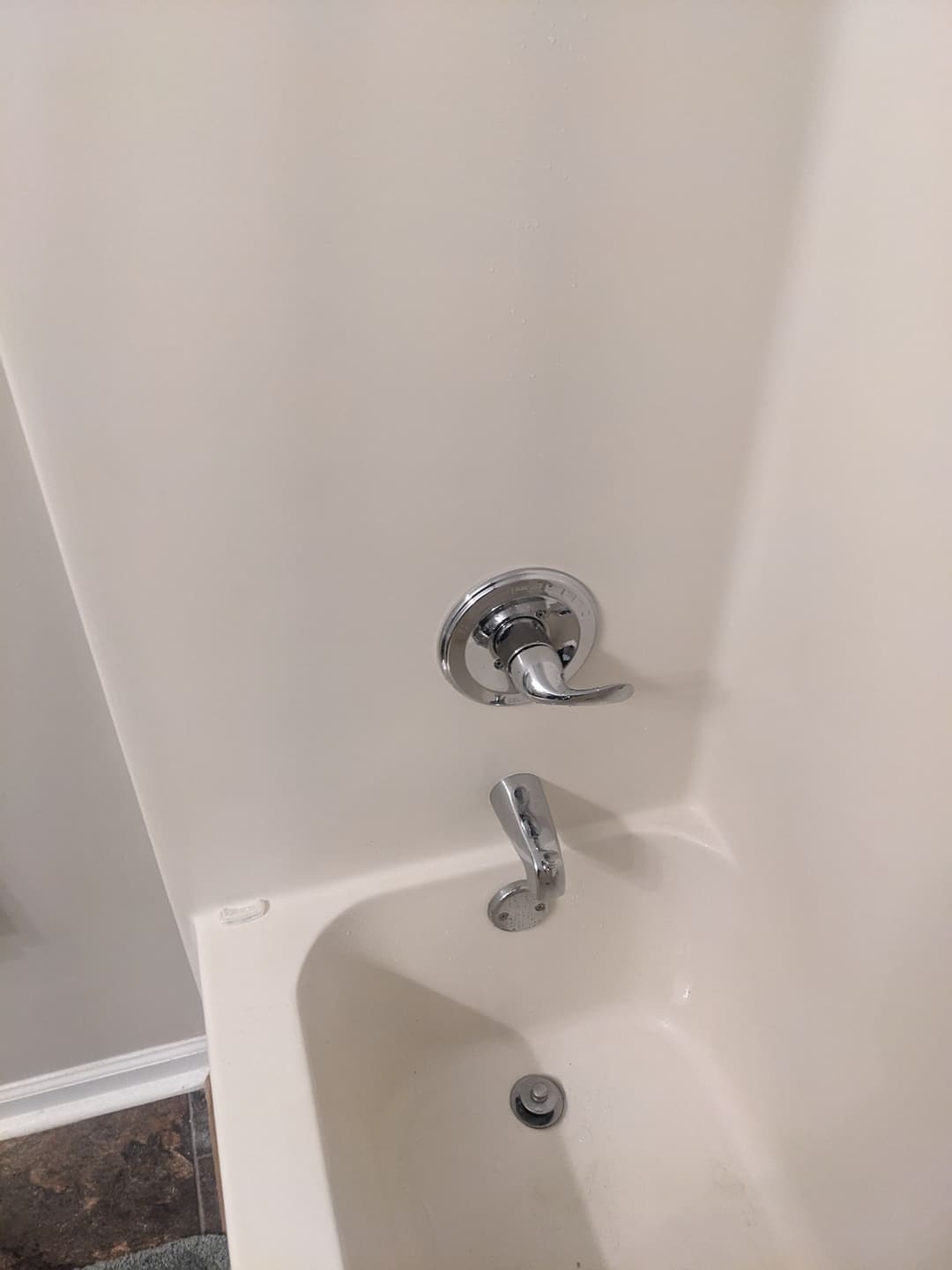 Chrome bathtub faucet and shower diverter in a clean, white tub. Modern bathroom design.