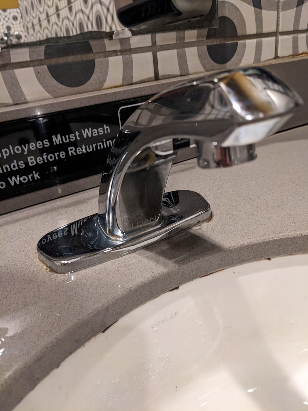 Chrome faucet in a bathroom sink with wash instructions displayed nearby.